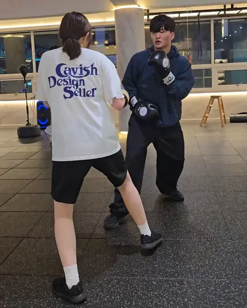 코치가 잡은 미트에 펀치를 넣는 여성 회원