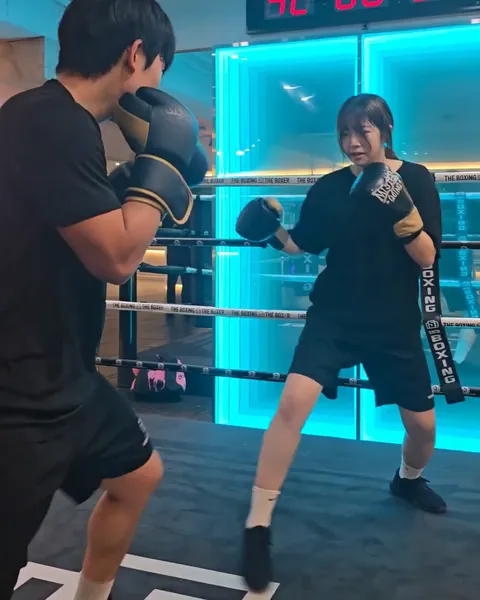 링 위에서 코치와 미트 수업을 하는 여성 회원
